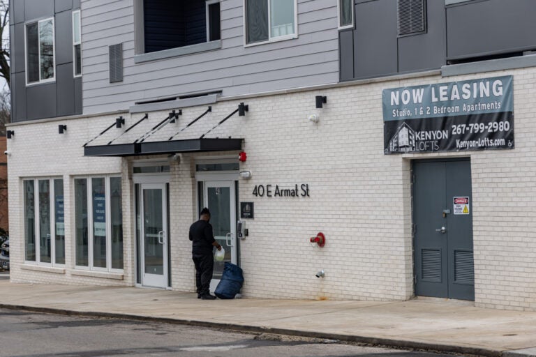 A building seen from the outside and a person entering it. The address reads 40 E. Armat St.