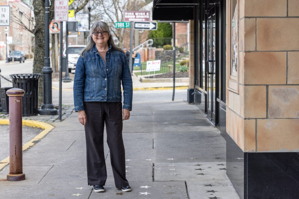 Bernadette Dougherty stands near the star donated by her and her family outside the Ambler Theater.
