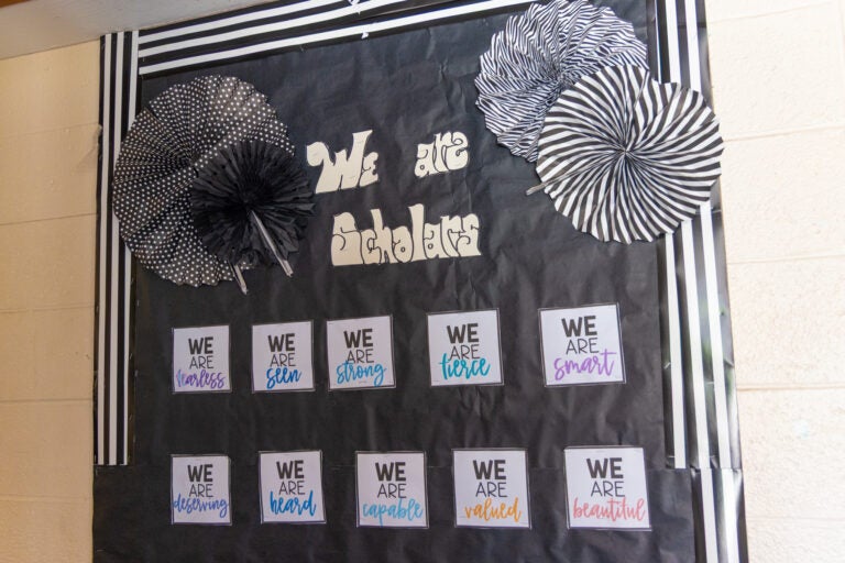 a wall piece reads We are Scholars and other motivational phrases