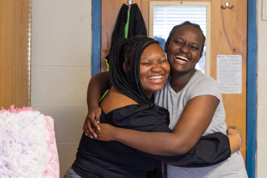 Roommates Chobe and Joy hug and smile at the HomeWorks Trenton