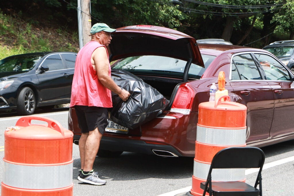 a person takes trash out of their car trunk