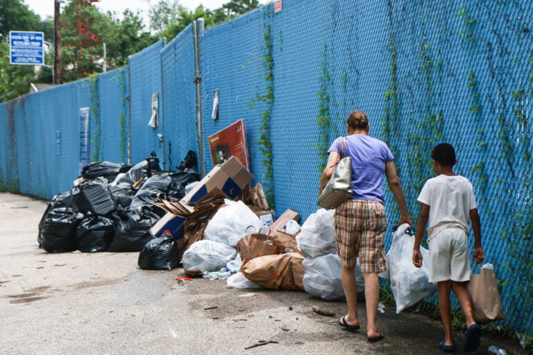 a woman and child drop off trash outside the Northwest Sanitation Convenience Center