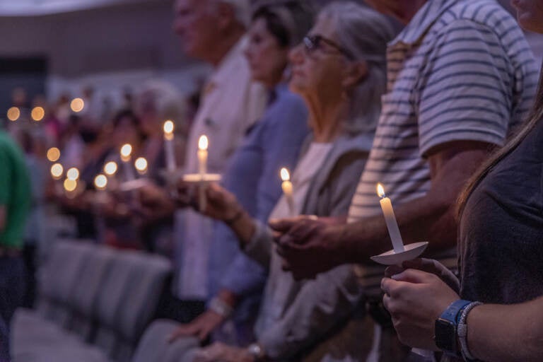 A close-up of people holding candles at a vigil in Upper Makefield.