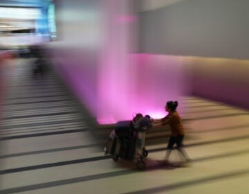 A traveler pushes a luggage cart through the international arrivals area at the international airport in Los Angeles
