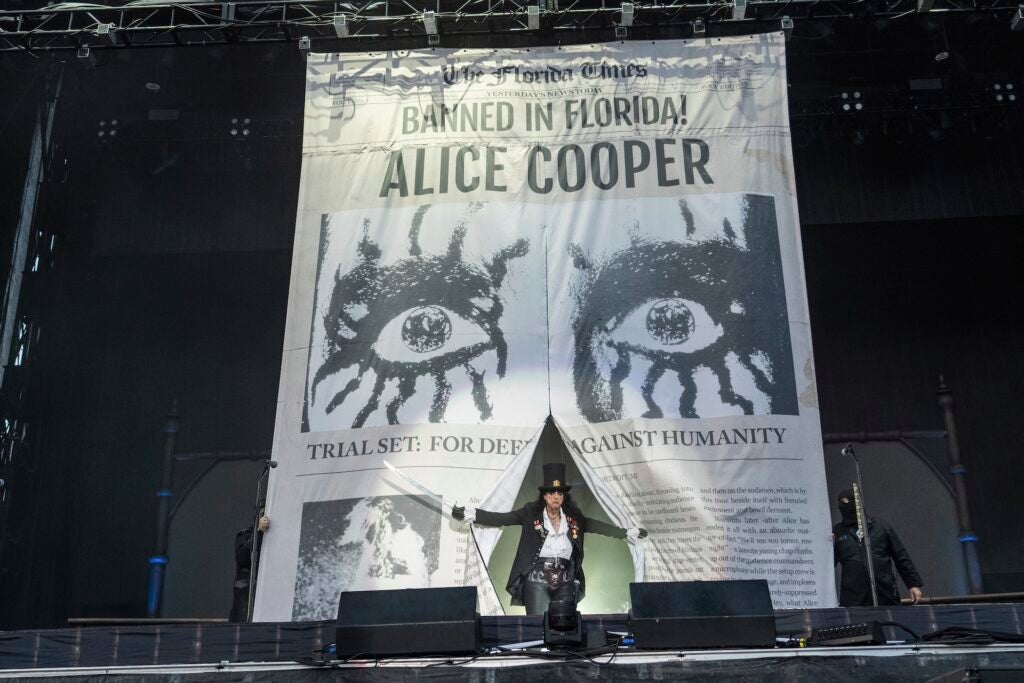 Alice Cooper entering the stage from behind a large backdrop