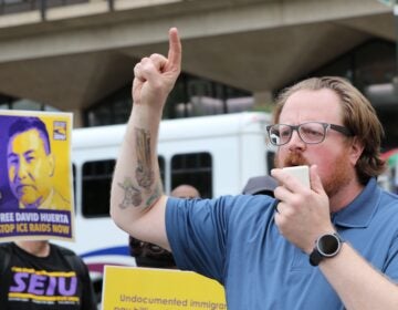A man speaking into a megaphone at the protest