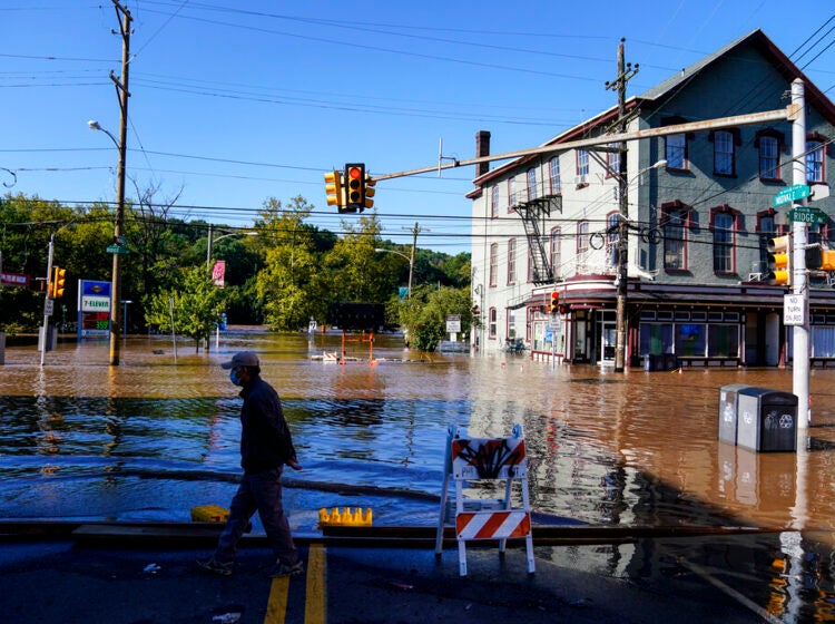 A person walks on a flooded street