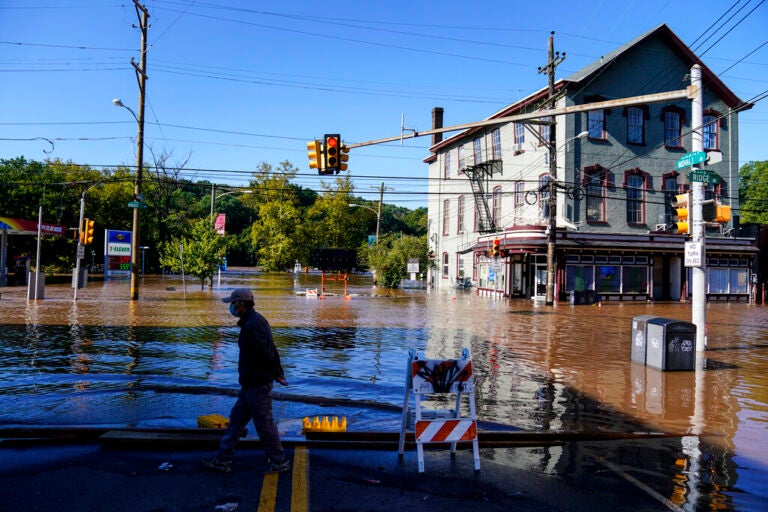 A person walks on a flooded street