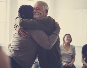Old guy consoling a woman with a hug