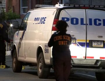 Officers are seen next to a police vehicle in Philadelphia