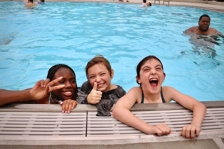 three children playing in a pool