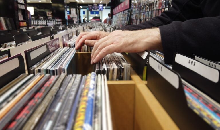 Close up of hands flipping through lps in a large record shop.