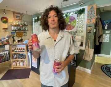 Jesse Ginefra with cans of the drink in his store