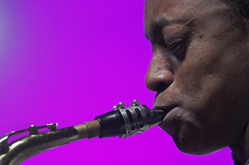 A closeup of Lakecia Benjamin playing the saxophone on stage