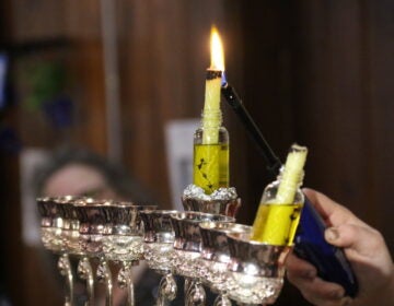 Rabbanit Dasi Fruchter lights the menorah