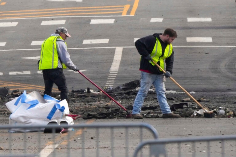 Workers sweeping debris