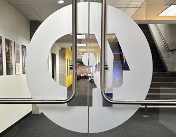 The PBS logo is on interior double glass doors leading into an office