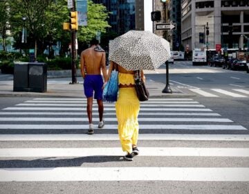 A woman uses an umbrella for shade in Philadelphia