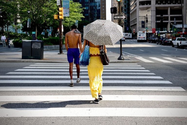 A woman uses an umbrella for shade in Philadelphia