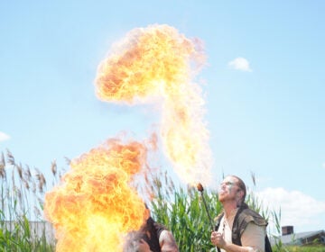 Bella GreenWolf and Daniel GreenWolf breathe fire to cap off their performance. (Kenny Cooper/WHYY)