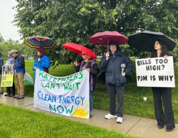 Protesters outside in the rain under umbrellas