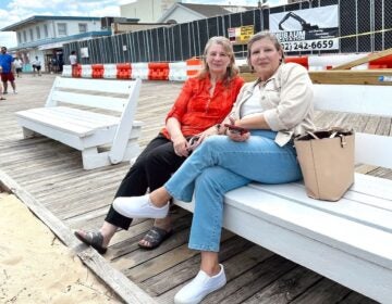 Long time Rehoboth Beach visitors pose for photo on benches at boardwalk