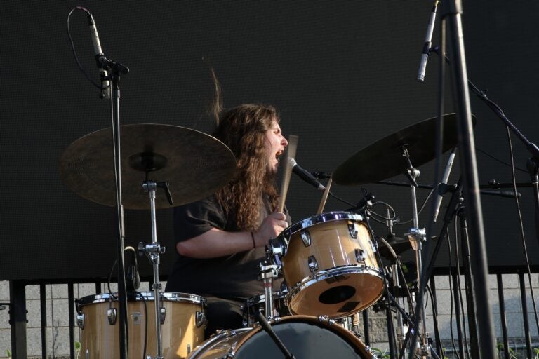 a member of The Lunar Year playing drums and singing at Spruce Street Harbor Park