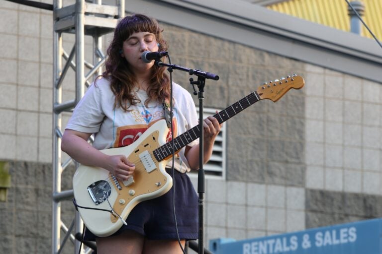 a member of the band Juuulian singing and playing electric guitar at Spruce Street Harbor Park