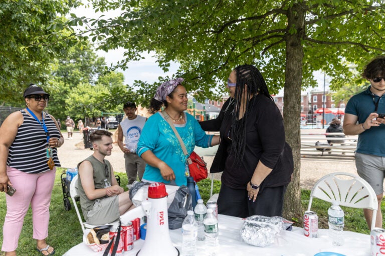 Trenton community member, Janice Bailey, center, hugs Sarah Glover