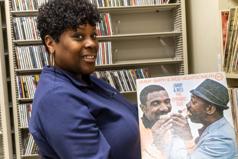 Nicole Sweeney holds an LP by artists Jimmy Smith and Wes Montgomery